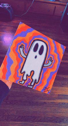 a person holding up a piece of art with a ghost on it