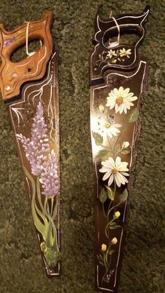 two metal vases with flowers painted on them