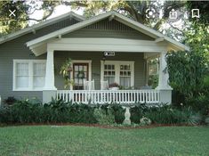 a gray house with white trim and porch