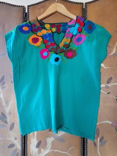 "70s lovely bright emerald green blouse with bright embroidery Black stitching at cuffs and around the V- neck Bust across 21\" (42\" around) Length 23\" Across shoulders 21\" Arm openings 16\" around **a couple of very light blue Mark's on left side. Little mend at bottom left side" Traditional Green Blouse For Spring, Traditional Green Embroidered Top For Spring, Green Casual Blouse For Festival, Green Traditional Embroidered Top For Spring, Green Cotton Festival Blouse, Bohemian Green Tops For Festivals, Green Embroidered Short Sleeve Top For Spring, Bohemian Green Embroidered Top For Festival, Bohemian Green Embroidered Top For Summer