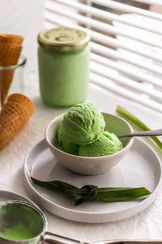 a bowl filled with green ice cream on top of a white plate