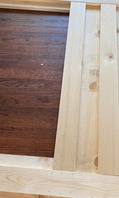 the bottom part of a wooden frame with wood flooring in it and one piece missing