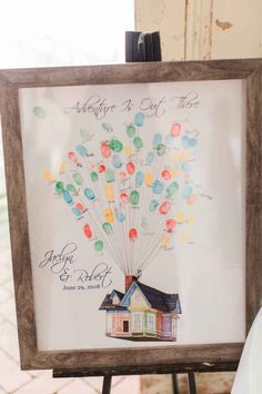 a family tree with balloons in the shape of a house is displayed on a easel