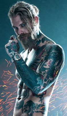 a man with tattoos on his arms and chest standing in front of some firework