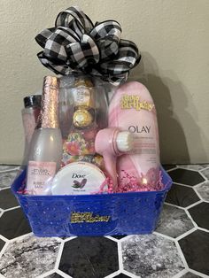 a blue basket filled with personal care items on top of a tiled floor next to a wall