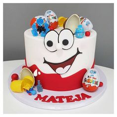 a birthday cake with an assortment of toys on it's top and the words matera written in red