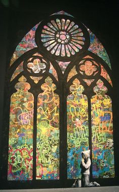 a large stained glass window with graffiti all over it