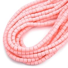 pink beads are lined up on a white surface