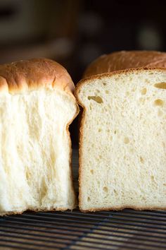 two loaves of white bread sitting on top of a cooling rack next to each other