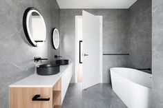 a bathroom with two sinks and a bathtub next to a mirror on the wall