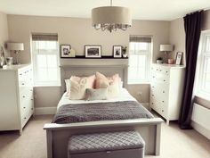 a bedroom with a bed, dressers and pictures on the wall