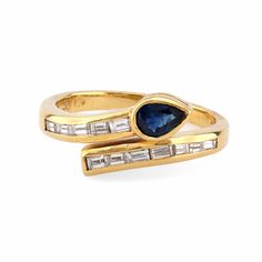 Center Stone: Pear Shape Blue Sapphire Weight: .23 Carat Accent Stone: 12 Baguette Cut Diamonds Weight: .33 Carats Color: F Clarity: VS Metal: 18K Yellow Gold Era: Modern Circa: 2020's Hallmarks: Stone Weight Engraved, Purity and Maker Mark Size: 5.75 and can be resized Gram weight: 3.79 This captivating modern snake bypass ring, crafted in 18K yellow gold, features a stunning .23 carat pear shape blue sapphire at its center. The sapphire is beautifully complemented by 12 baguette cut diamonds, totaling .33 carats, graded F in color and VS in clarity. The sleek and contemporary design, hallmarked with engraved stone weight, purity, and maker marks, adds a unique touch to this elegant 2020s piece. Weighing 3.79 grams and sized at 5.75, this ring is both bold and graceful, making it a stando Luxury Elegant Open Sapphire Ring, Luxury Unique Open Sapphire Ring, Unique Rings Vintage, Stone Engraving, Platinum Diamond Engagement Rings, Platinum Diamond Rings, Gold Cocktail Ring, Bypass Ring, Platinum Engagement Rings