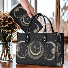 Boho Witch Triple moon child top handles Vegan leather Tote handbag, Witchy Goth celestial purse & shoulder strap, cross body bag gift Handbag: Sizes: Small, Medium, Large, available  Material: Choose from top-rated vegan Leather with faux leather pattern. All-Over Printing: Unique Sense Forest style art. Convenient Carrying: Sturdy dual top handles for balance and comfort. Style Options: Removable and adjustable strap for versatile looks and crossbody style. Secure Closure: Smooth zipper closur Boho Witch, Checkbook Wallet, Children Top, Vegan Leather Tote, Cross Body, Leather Handbags Tote, Leather Pattern, Moon Child, Tote Handbags