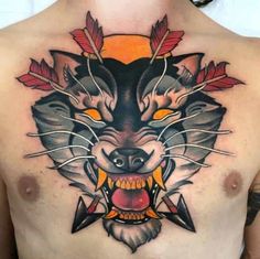 a man's chest with a wolf tattoo on it