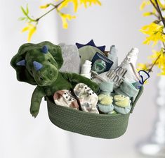 a green basket filled with baby items on top of a table