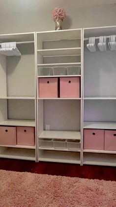 an organized closet with pink drawers and white shelving units in the middle of it