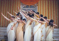 a group of women in white sari dancing