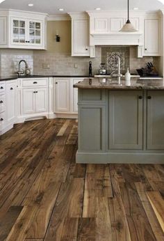 a kitchen with wood floors and white cabinets