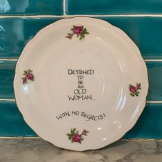 a white plate with pink roses on it that says destined to be worn with no regretss