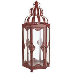 a red metal lantern with an intricate design on the top and bottom, sitting against a white background