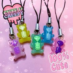 four different colored bears are hanging from lanyards on a pink background with hearts