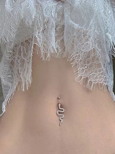 a woman with her stomach covered in white lacy gauze and a snake charm on the side