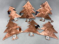 a group of copper christmas trees with numbers on them and numbered for each ornament