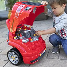 a little boy playing with a toy car