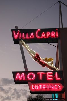 the neon sign for villa capri motel entrance is lit up in red and yellow