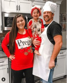 a man and two girls are standing in the kitchen