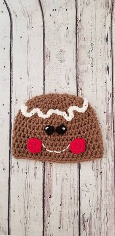 a brown crocheted hat with white and red eyes