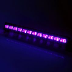 a purple light in the dark on a white surface with blue lights around it and black background