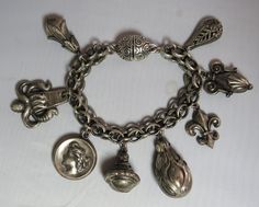 Here's a chunky 1950s charm bracelet in silver tone metal.  It features a wide chain and 8 large charms that are styled like vintage watch fobs.  Measures 7 long and is in good vintage condition with a magnetic clasp.   Please see the picture with a coin for size comparison, as items may appear larger than they actually are. This is necessary to provide accurate details. Thanks for looking. And thank you for shopping sustainably. Retro Silver Jewelry With Charms, Vintage Nickel Free Silver Charms, Retro Silver Metal Charm Bracelet, Retro Silver Bracelets With Charms, Antique Charm Bracelet With Vintage Charm, Vintage Metal Charm Bracelet, Silver Retro Bracelets With Charms, Collectible Vintage Charm Metal Bracelet, Silver Metal Bracelets Vintage