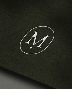 the letter m is inscribed in white on a black background