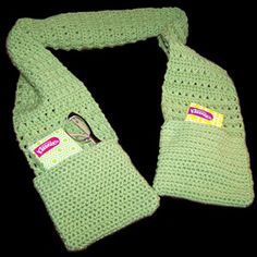 a green crocheted scarf with scissors on it