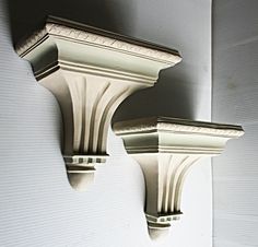 two white wall sconces mounted to the side of a building