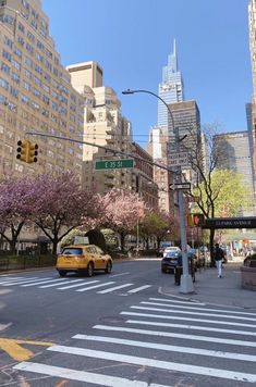 a yellow taxi is stopped at an intersection in the city