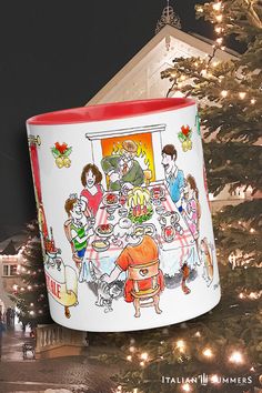 a large coffee mug with an image of family around the dinner table on it in front of a christmas tree