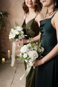 two women standing next to each other holding bouquets