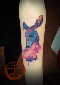 a colorful deer tattoo on the left forearm and right leg, with space in the background