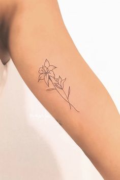 a woman's arm with a flower tattoo on the left side of her arm