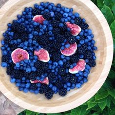 a bowl filled with blueberries and watermelon on top of a wooden table