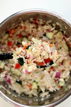 a bowl filled with rice and veggies on top of a white countertop