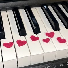 two hearts are placed on the keys of a piano