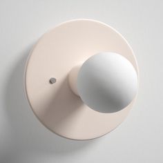 a light that is on the side of a white wall mounted device with a round button