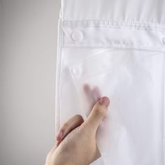 a person's hand reaching for a plastic bag on top of a white sheet