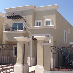 a house that has a gate in front of it and some windows on the side