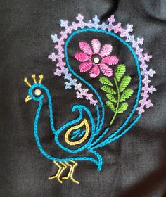 a close up of a bird with flowers on it's head and an embroidered design on its back