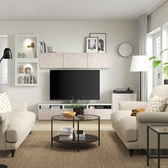 a living room filled with furniture and a flat screen tv mounted on a wall next to a window