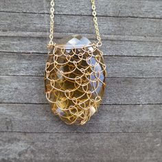 Our classic fishnet necklace! Each stone one of a kind. Hand wrapped in gold-filled wire. 18" total length. Cognac Quartz is one of the birthstones for the Capricorn sign. It is considered a grounding as well as a protection stone so it will both protect you from negativity and ground you. Many believe that this gorgeous stone also one of endurance and creativity in business. ﻿﻿Handmade in Ojai, California. Oval Gold Wire Wrapped Necklaces, Gold Oval Wire Wrapped Necklace, Oval Gold Wire Wrapped Necklace, Yellow Gold Oval Wire Wrapped Necklace, Knotless Netting, Wire Wrap Cabochon, Perfume Container, Ojai California, Capricorn Sign